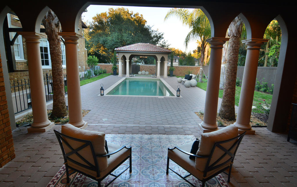 Foto på en mellanstor medelhavsstil pool på baksidan av huset, med spabad