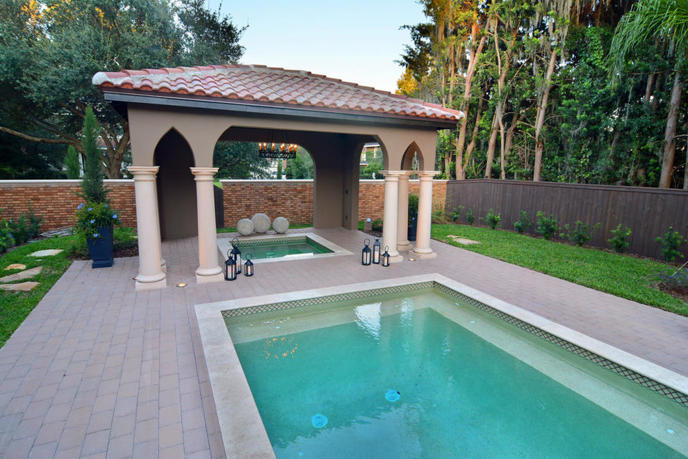 Inspiration for a medium sized mediterranean back rectangular lengths hot tub in Jacksonville with brick paving.