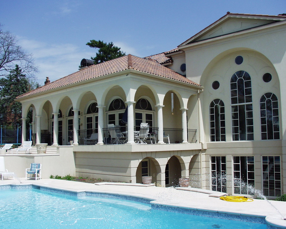 Example of a large tuscan backyard stone and custom-shaped pool design in Kansas City