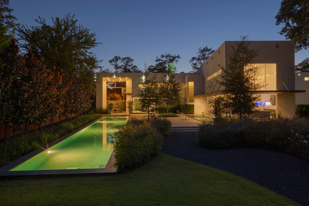 Diseño de piscina minimalista de tamaño medio rectangular en patio trasero con adoquines de hormigón