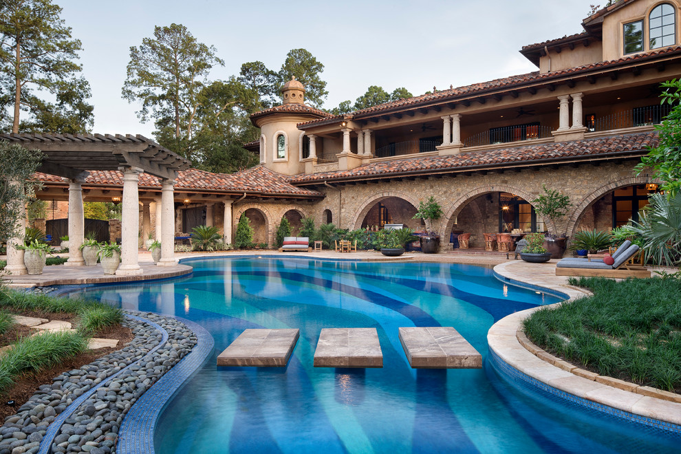 Immagine di un'ampia piscina mediterranea personalizzata dietro casa