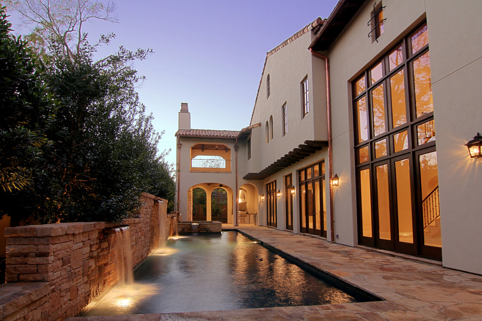 Diseño de piscina con fuente mediterránea rectangular en patio trasero