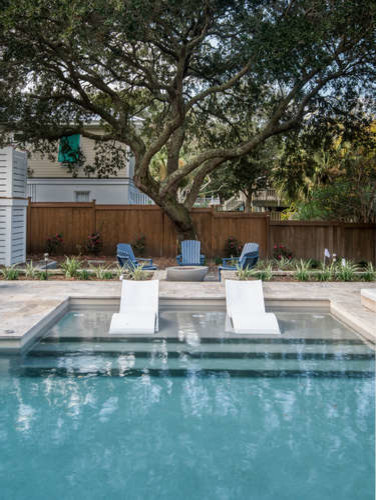 Foto de piscina con fuente natural marinera de tamaño medio en forma de L en patio trasero con adoquines de piedra natural