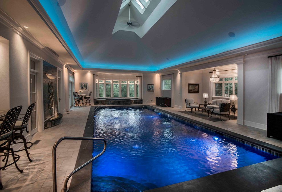 Пример оригинального дизайна: спортивный, прямоугольный бассейн среднего размера в доме в классическом стиле с джакузи и покрытием из каменной брусчатки