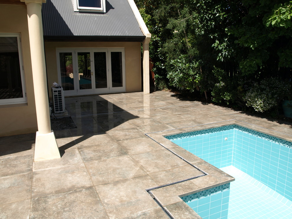 Идея дизайна: большой прямоугольный бассейн на заднем дворе в современном стиле с покрытием из плитки