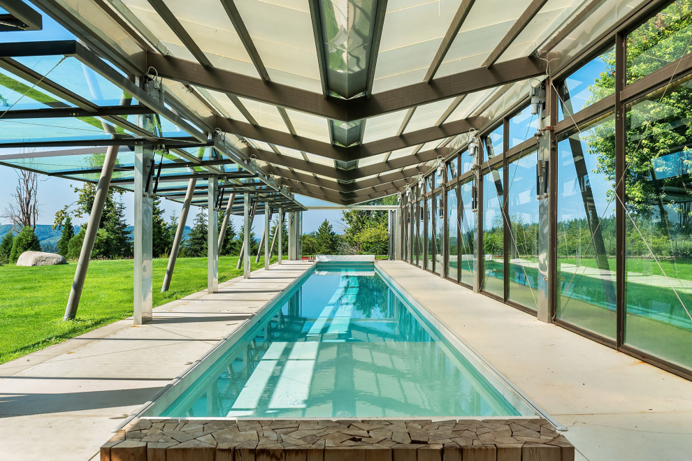 Diseño de piscina alargada actual rectangular en patio lateral con losas de hormigón