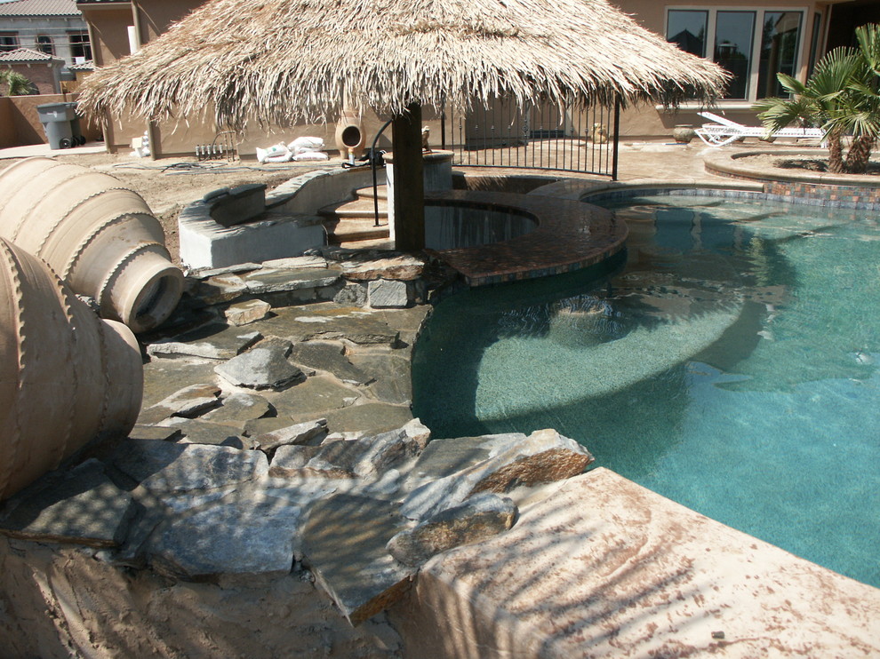 Cette photo montre une piscine naturelle et arrière exotique de taille moyenne et sur mesure avec du béton estampé et un bain bouillonnant.