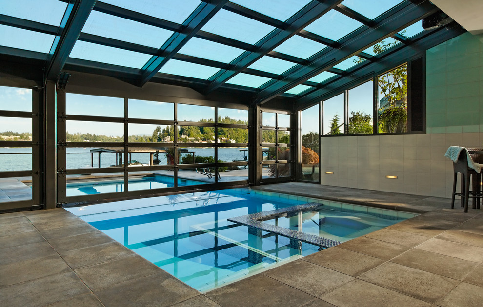 Inspiration pour une grande piscine design rectangle avec un bain bouillonnant et des pavés en béton.