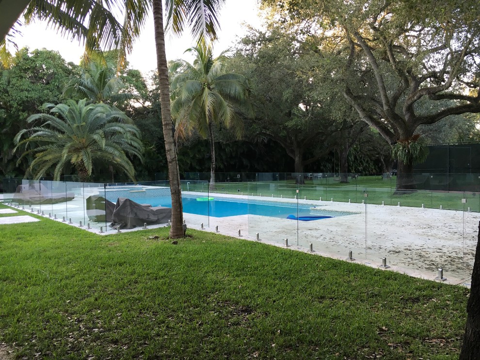Modelo de piscina marinera grande rectangular en patio trasero con losas de hormigón