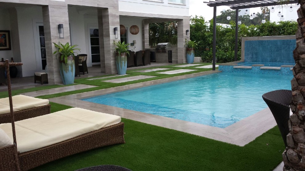 Foto di una piscina minimal rettangolare di medie dimensioni e dietro casa con cemento stampato e una vasca idromassaggio