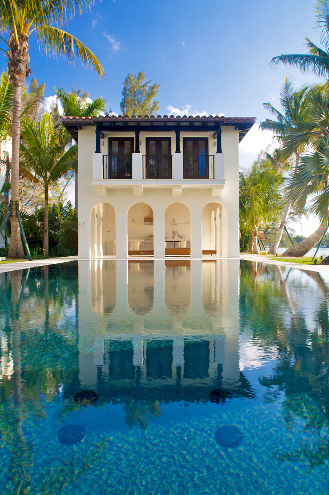 На фото: прямоугольный бассейн в средиземноморском стиле с домиком у бассейна с