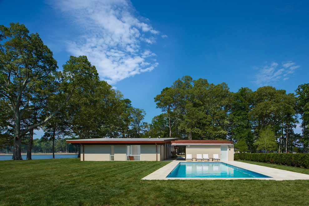 Foto di una grande piscina monocorsia moderna rettangolare nel cortile laterale con pavimentazioni in pietra naturale