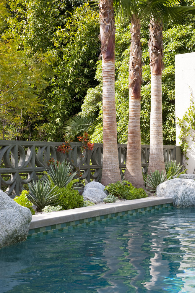 Immagine di una piscina monocorsia minimalista rettangolare di medie dimensioni e dietro casa con pavimentazioni in cemento