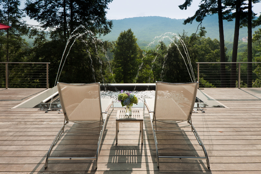 Inspiration pour une piscine arrière vintage de taille moyenne et rectangle avec un bain bouillonnant et une terrasse en bois.