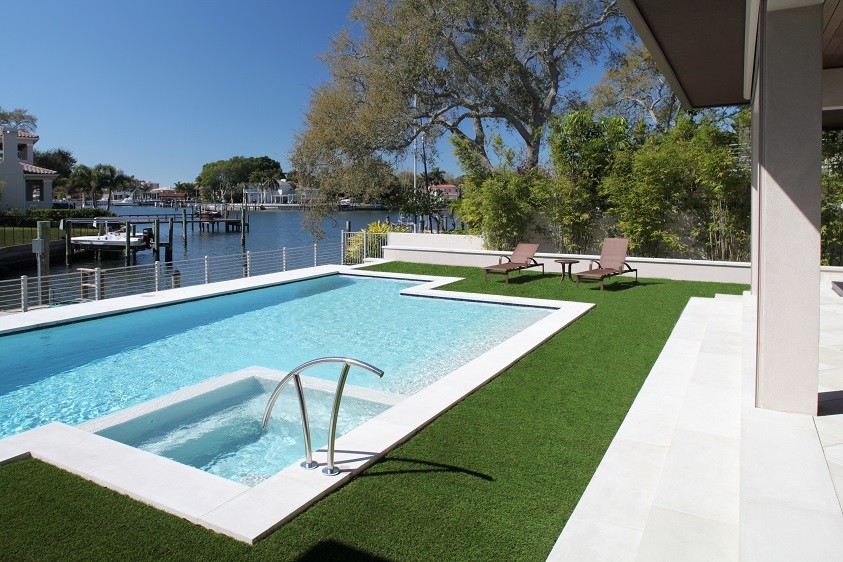 Idee per una grande piscina moderna rettangolare dietro casa con pavimentazioni in cemento