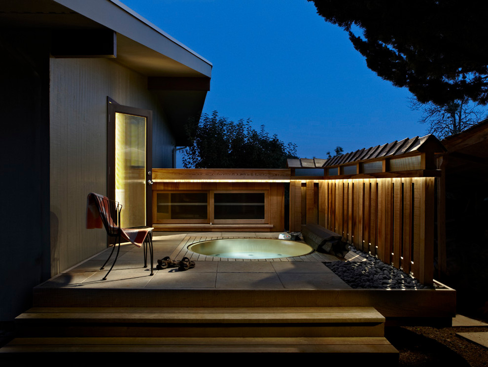 Идея дизайна: круглый бассейн среднего размера на заднем дворе в стиле ретро с джакузи и покрытием из плитки