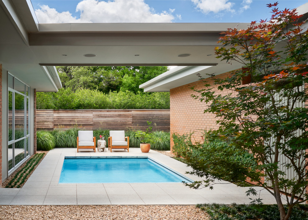 Стильный дизайн: прямоугольный бассейн среднего размера на боковом дворе в стиле ретро с мощением тротуарной плиткой - последний тренд