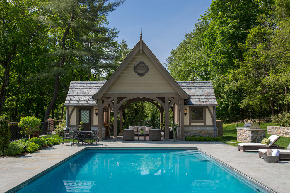 Imagen de piscina clásica grande en patio trasero con suelo de baldosas