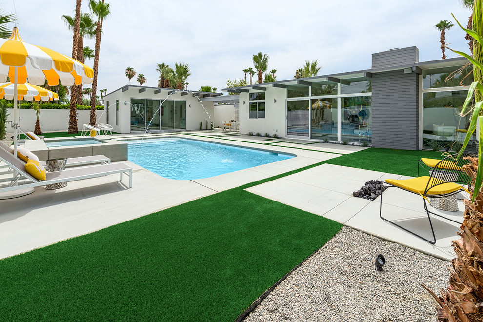 Foto di una piscina moderna rettangolare dietro casa con lastre di cemento