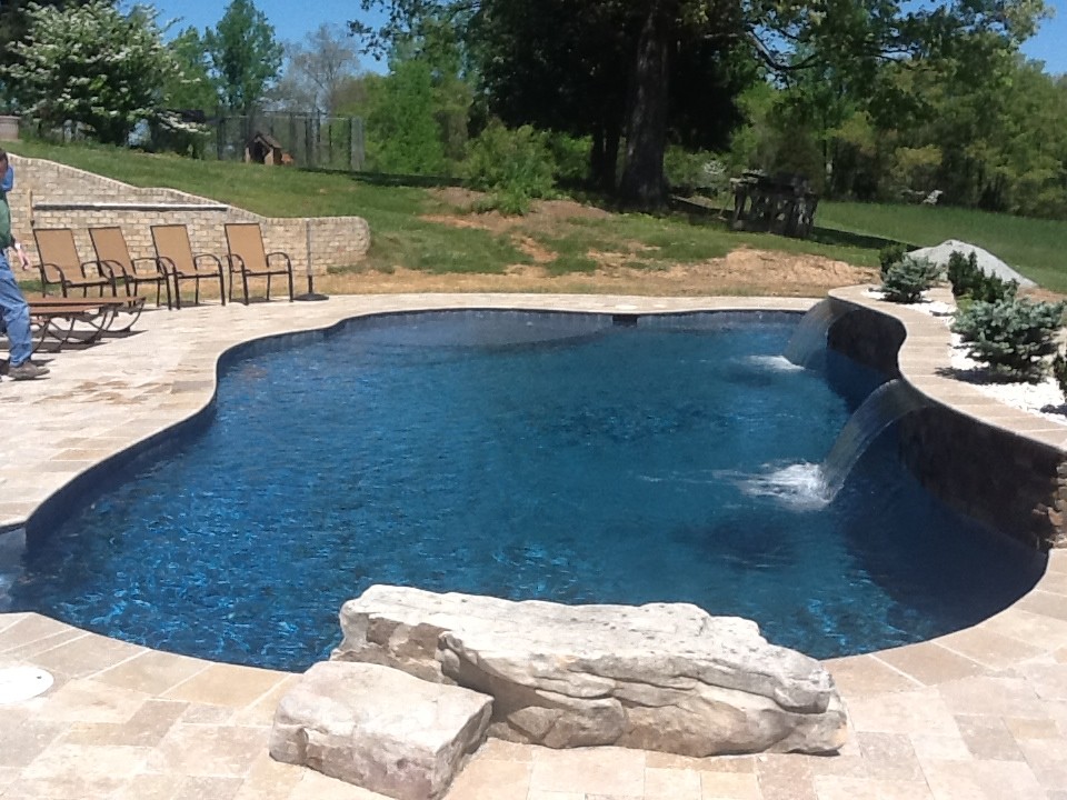 Mid-sized elegant backyard concrete and custom-shaped natural pool photo in Raleigh