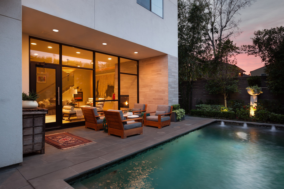 Пример оригинального дизайна: прямоугольный бассейн на заднем дворе в современном стиле с мощением тротуарной плиткой