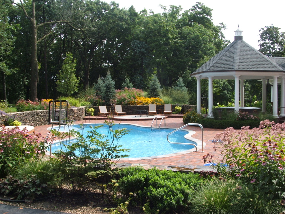 Inspiration for a traditional swimming pool in Chicago with brick paving.