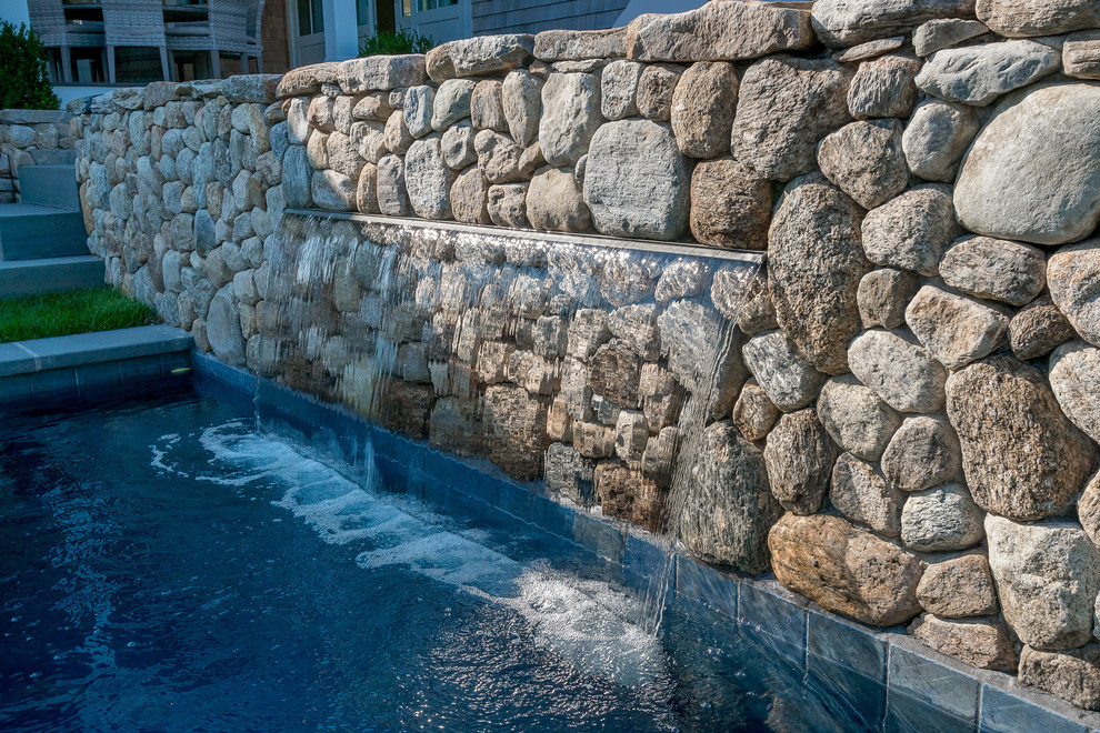 Foto di una grande piscina naturale stile marino rettangolare dietro casa con fontane e pavimentazioni in pietra naturale