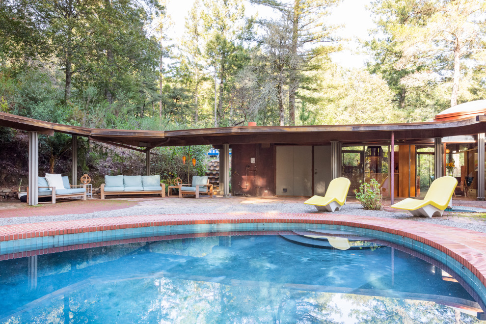 Example of a mid-century modern backyard brick and custom-shaped pool design in San Francisco