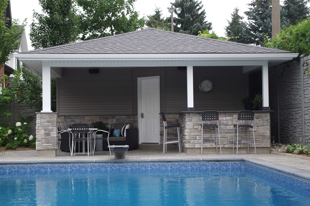 Example of a large classic backyard concrete paver and l-shaped pool house design in Toronto