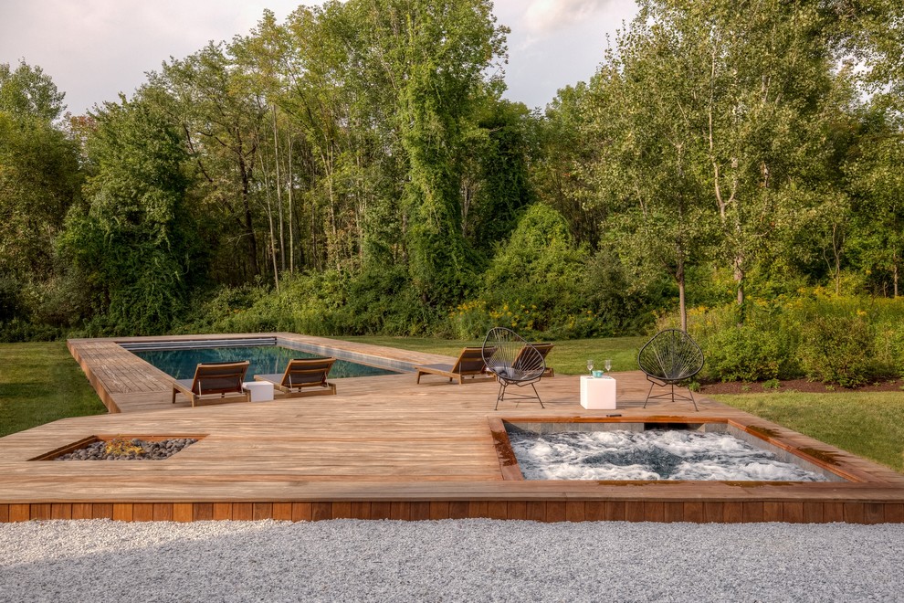 Idées déco pour une grande piscine avant contemporaine sur mesure avec un bain bouillonnant et une terrasse en bois.