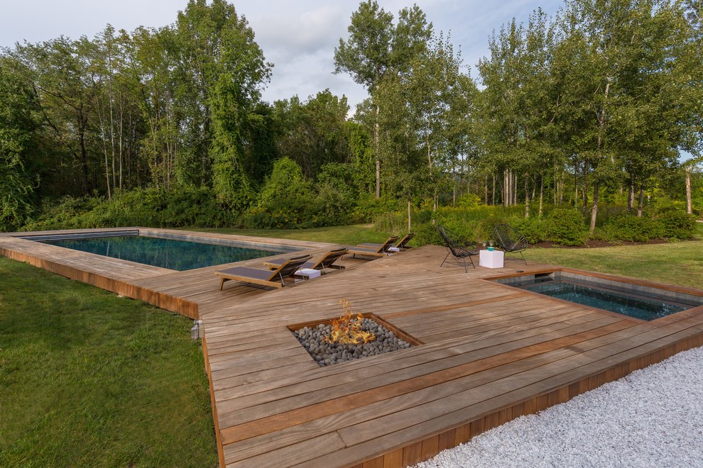 Immagine di una grande piscina contemporanea personalizzata davanti casa con una vasca idromassaggio e pedane