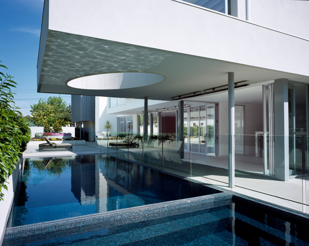 Foto di una piscina moderna rettangolare di medie dimensioni e dietro casa con una vasca idromassaggio