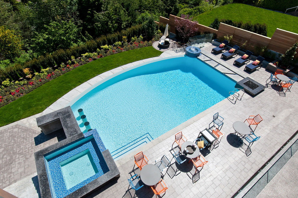 Foto di una grande piscina fuori terra minimalista personalizzata dietro casa con fontane e piastrelle