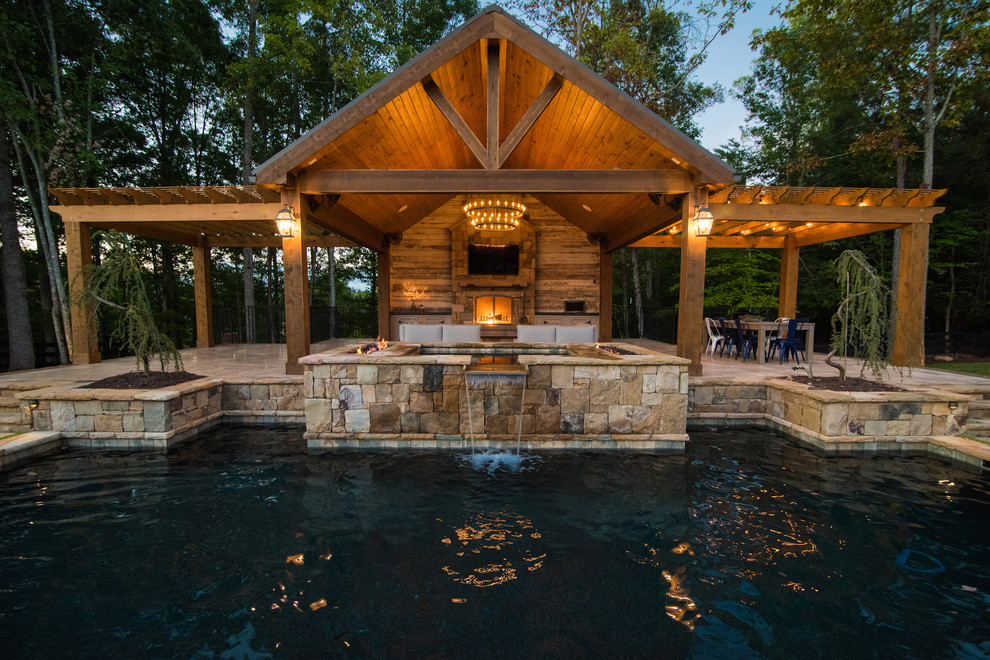На фото: большой бассейн произвольной формы на заднем дворе в стиле рустика с фонтаном и покрытием из каменной брусчатки