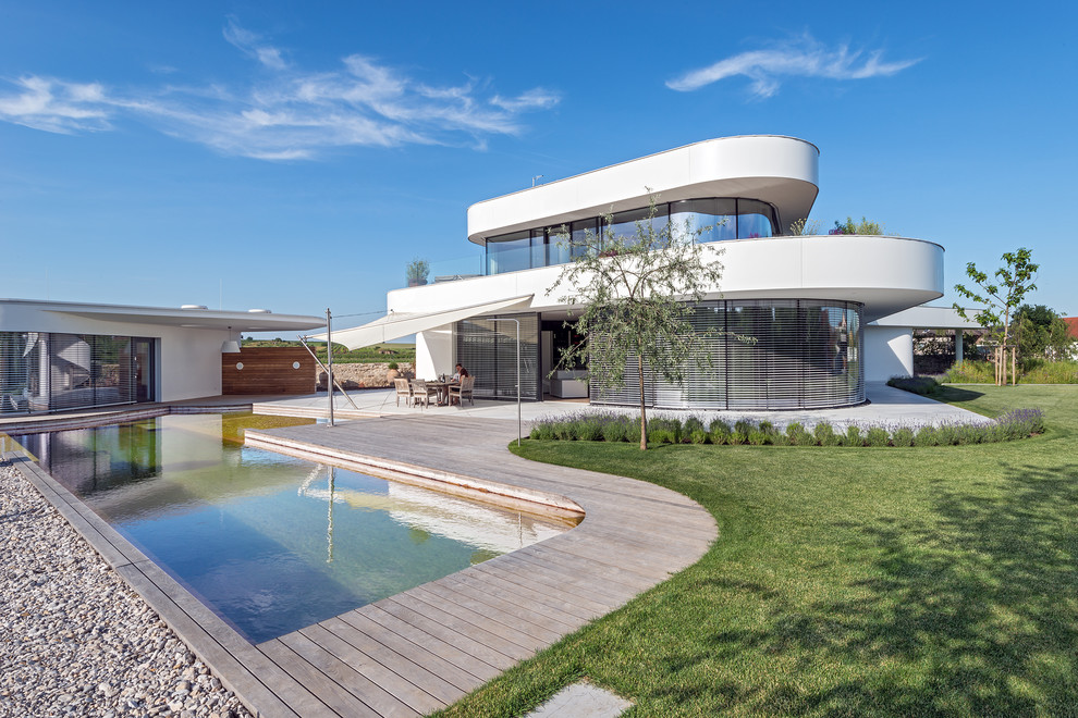Стильный дизайн: бассейн произвольной формы на заднем дворе в стиле модернизм с домиком у бассейна и настилом - последний тренд