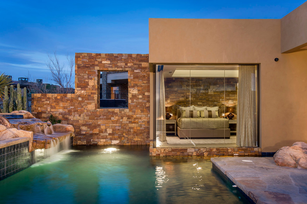 Diseño de piscina con fuente alargada de estilo americano extra grande a medida en patio trasero con adoquines de piedra natural