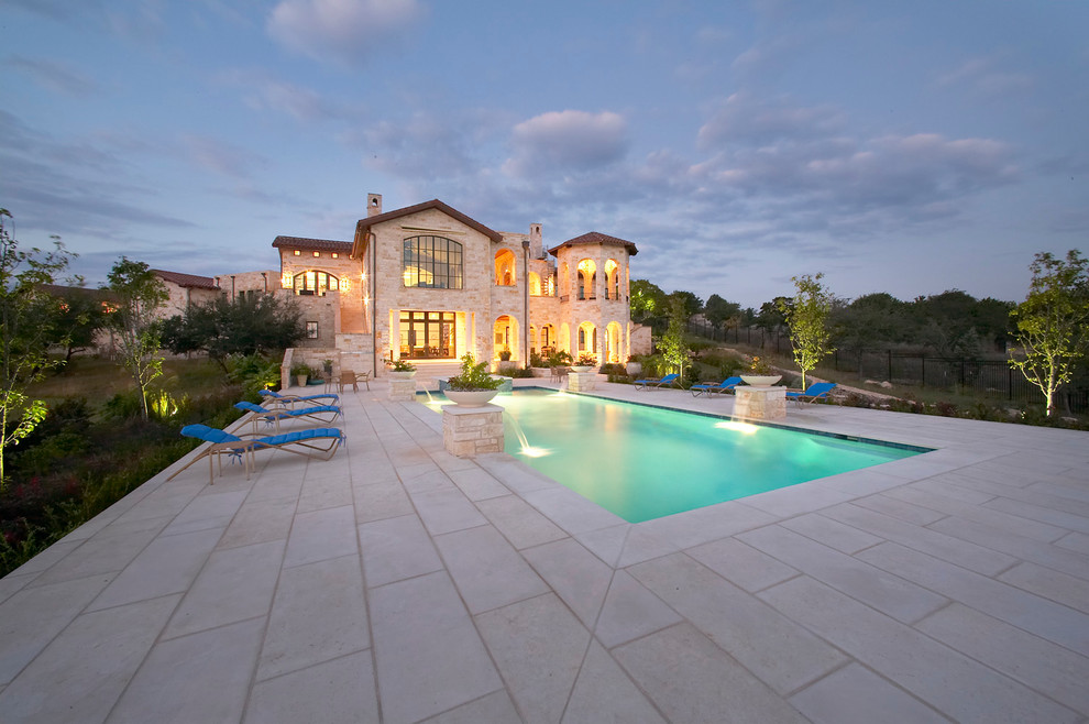 Example of a large tuscan backyard concrete paver and rectangular lap hot tub design in Austin