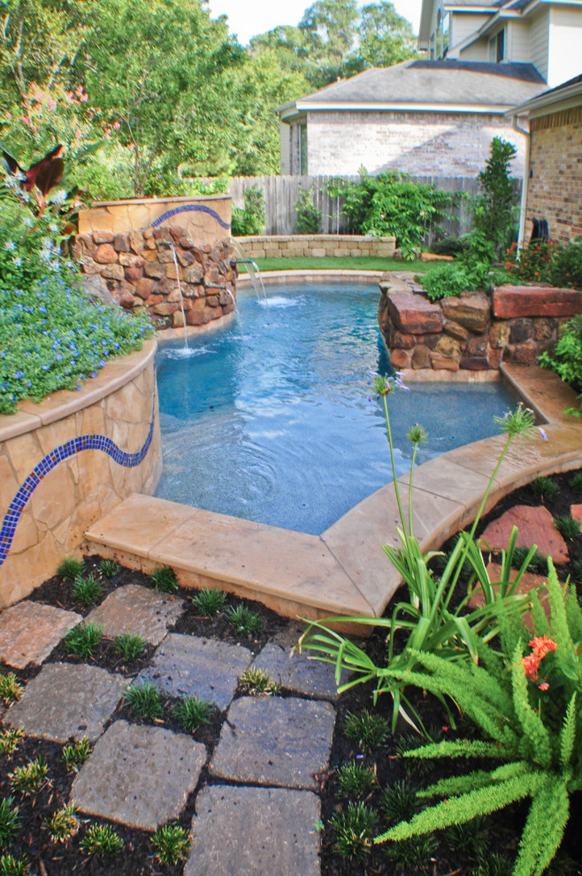 Ejemplo de piscina con fuente tradicional pequeña rectangular en patio trasero con adoquines de ladrillo