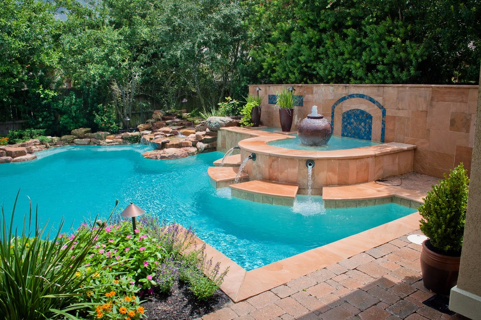 Idee per una piscina tradizionale personalizzata di medie dimensioni e dietro casa con fontane e pavimentazioni in pietra naturale