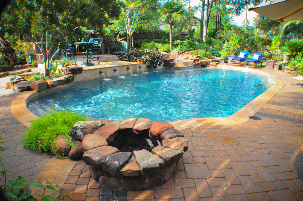 Ejemplo de piscinas y jacuzzis tradicionales de tamaño medio rectangulares en patio trasero con adoquines de ladrillo