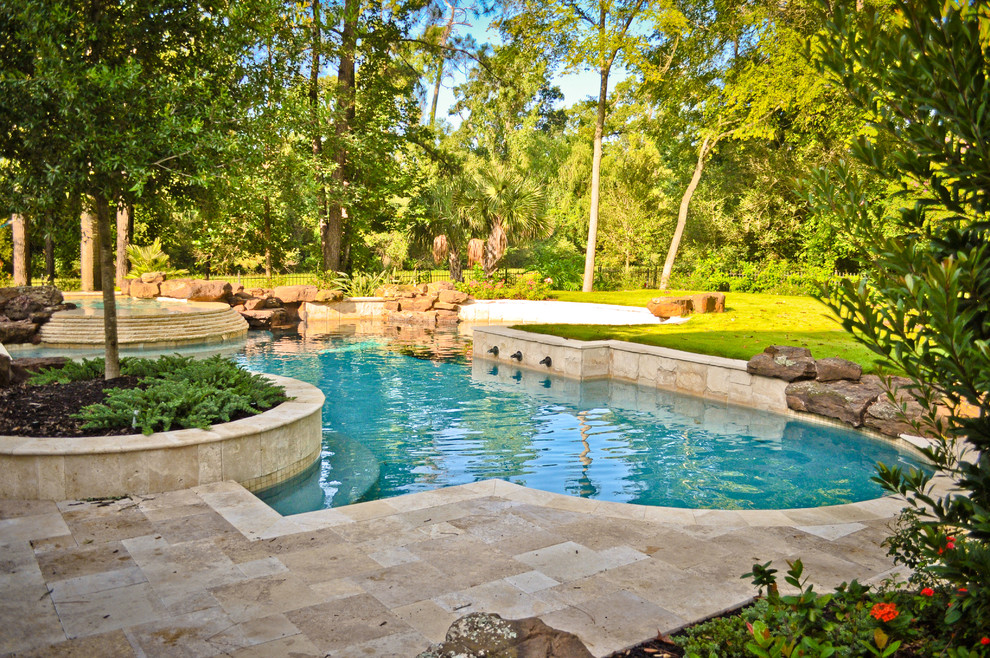 Ejemplo de piscina con fuente tradicional de tamaño medio a medida en patio trasero con adoquines de piedra natural