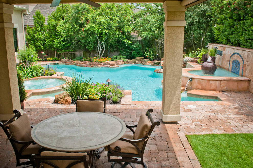 Example of a large classic backyard brick and custom-shaped pool fountain design in Houston