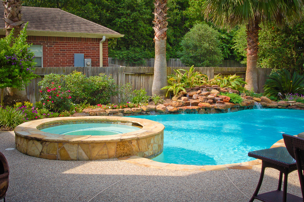 Large elegant backyard kidney-shaped hot tub photo in Houston with decking