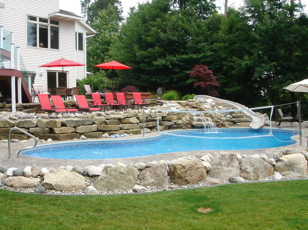 Large elegant backyard stone and custom-shaped water slide photo in Grand Rapids