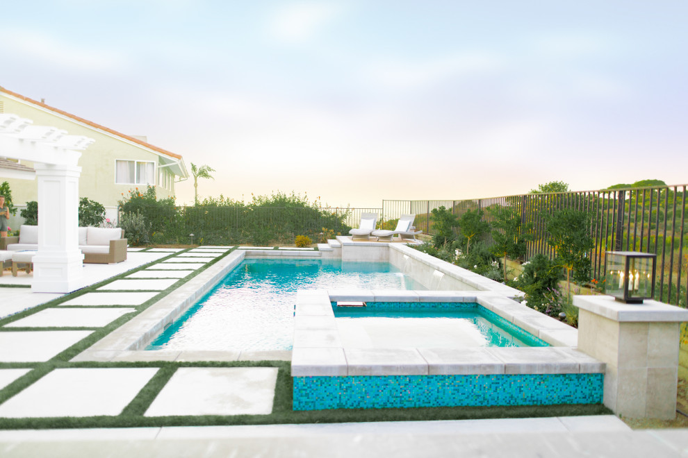 Immagine di una grande piscina naturale design rettangolare dietro casa con una vasca idromassaggio e pavimentazioni in cemento