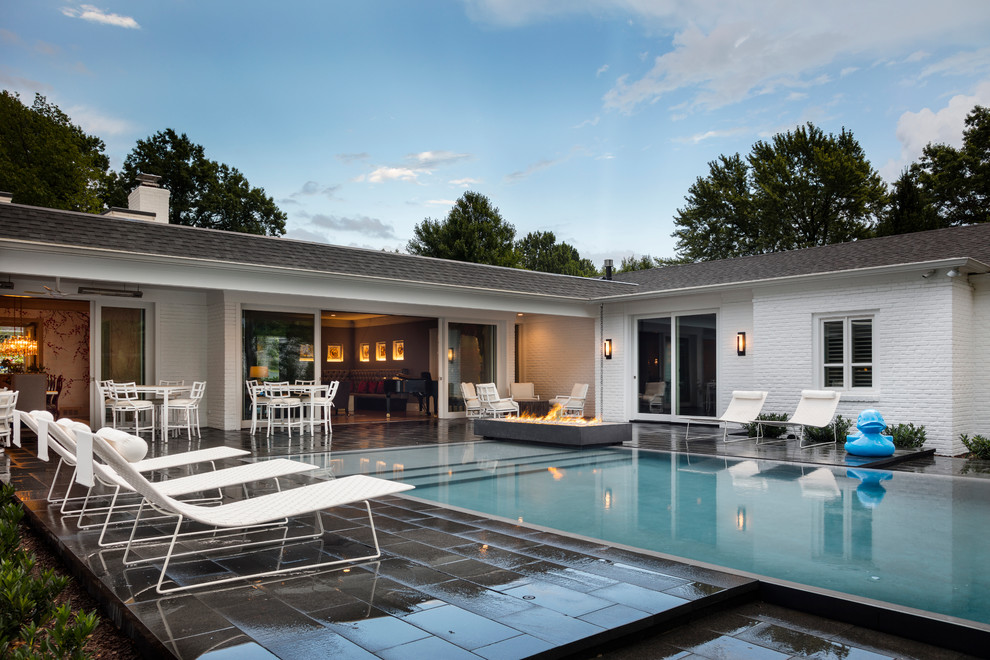 Pool - mid-sized transitional backyard stone and rectangular infinity pool idea in Kansas City