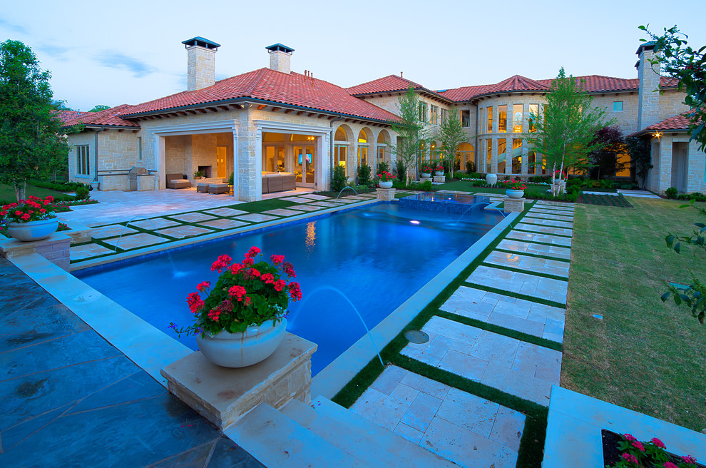 Esempio di una grande piscina contemporanea rettangolare dietro casa con fontane e pavimentazioni in pietra naturale