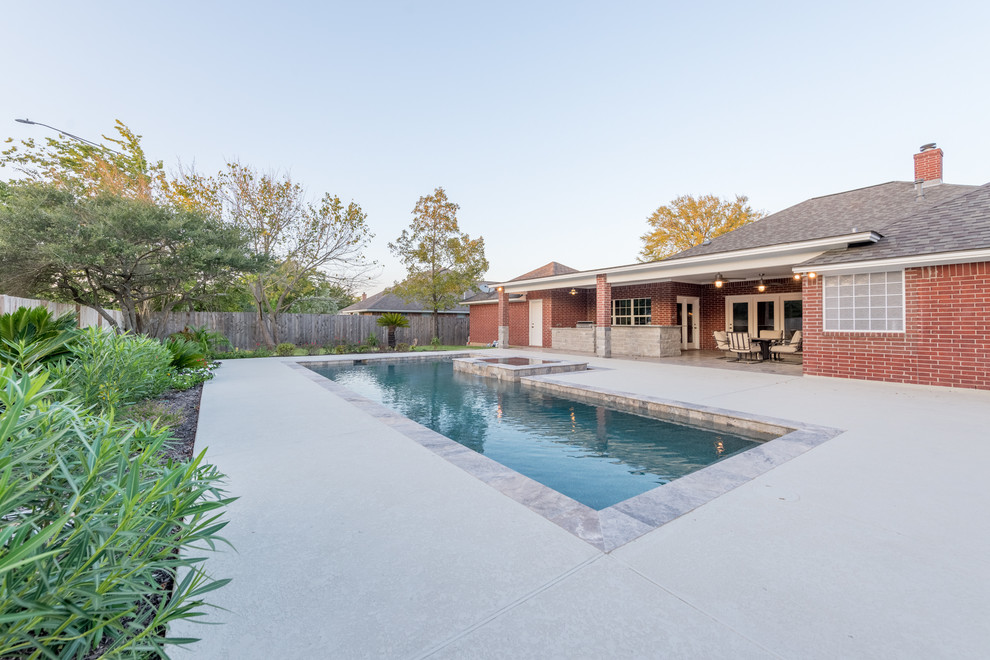 Foto di una piscina minimal personalizzata di medie dimensioni e dietro casa con una vasca idromassaggio e pavimentazioni in pietra naturale
