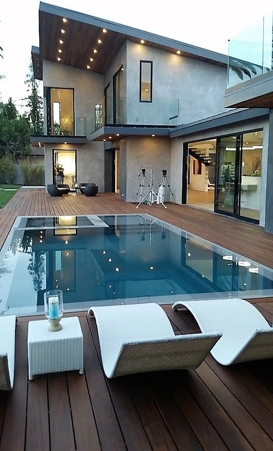 Foto di una piscina a sfioro infinito minimalista rotonda di medie dimensioni e dietro casa con una vasca idromassaggio