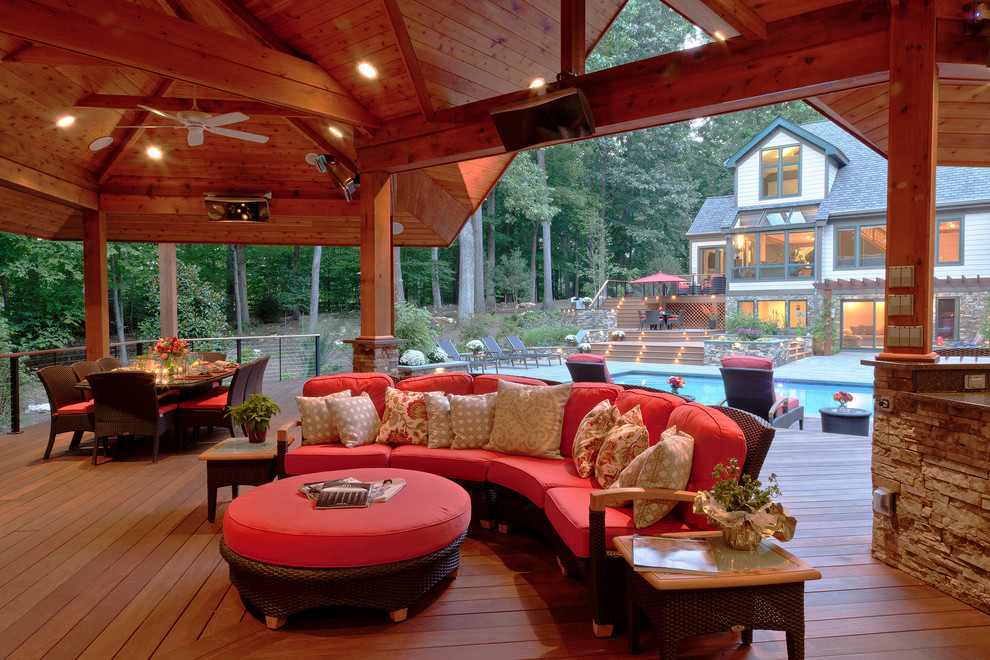 Idée de décoration pour une grande piscine arrière ethnique rectangle avec une terrasse en bois.